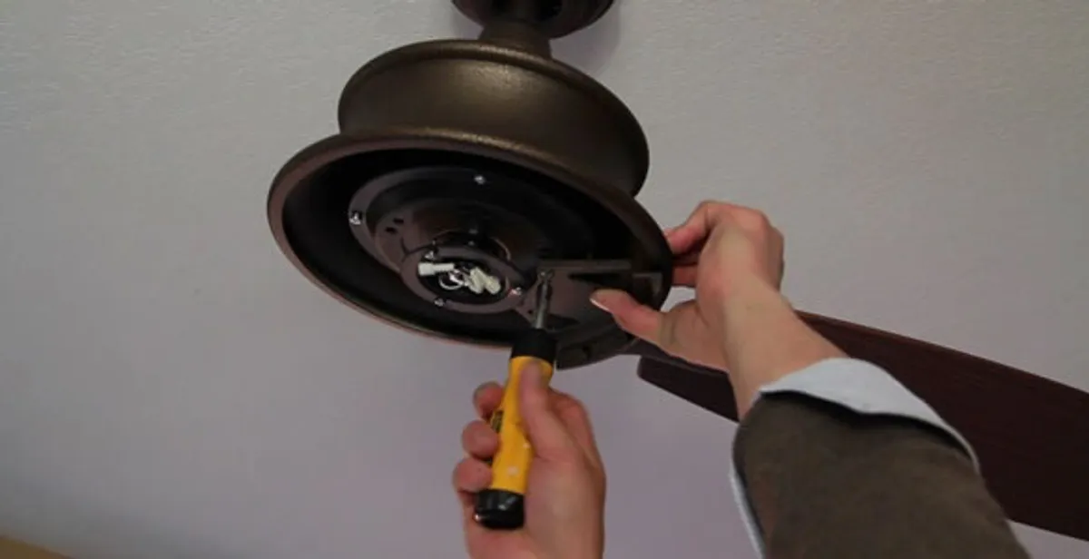 Electrician installing ceiling fan mounting bracket and fixture in Orange, CA